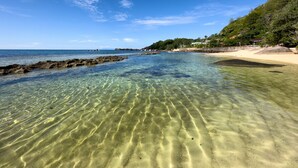 A clear beach with visible rock formations and a sandy shore. - Sea Splash & La Petite Maison (Praslin Island)