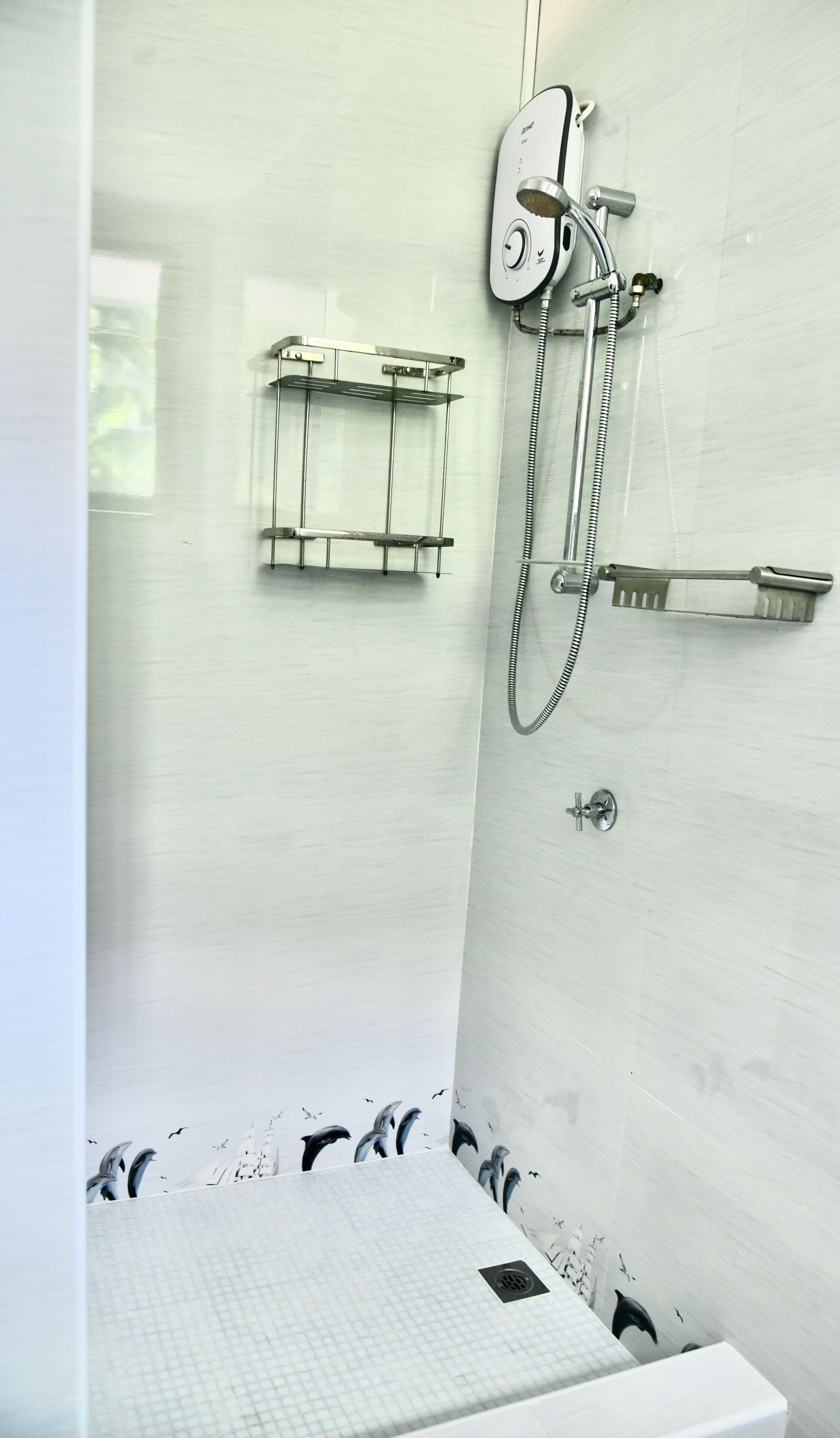 A bathroom with a glass shower enclosure, a white sink, and a towel rack.
