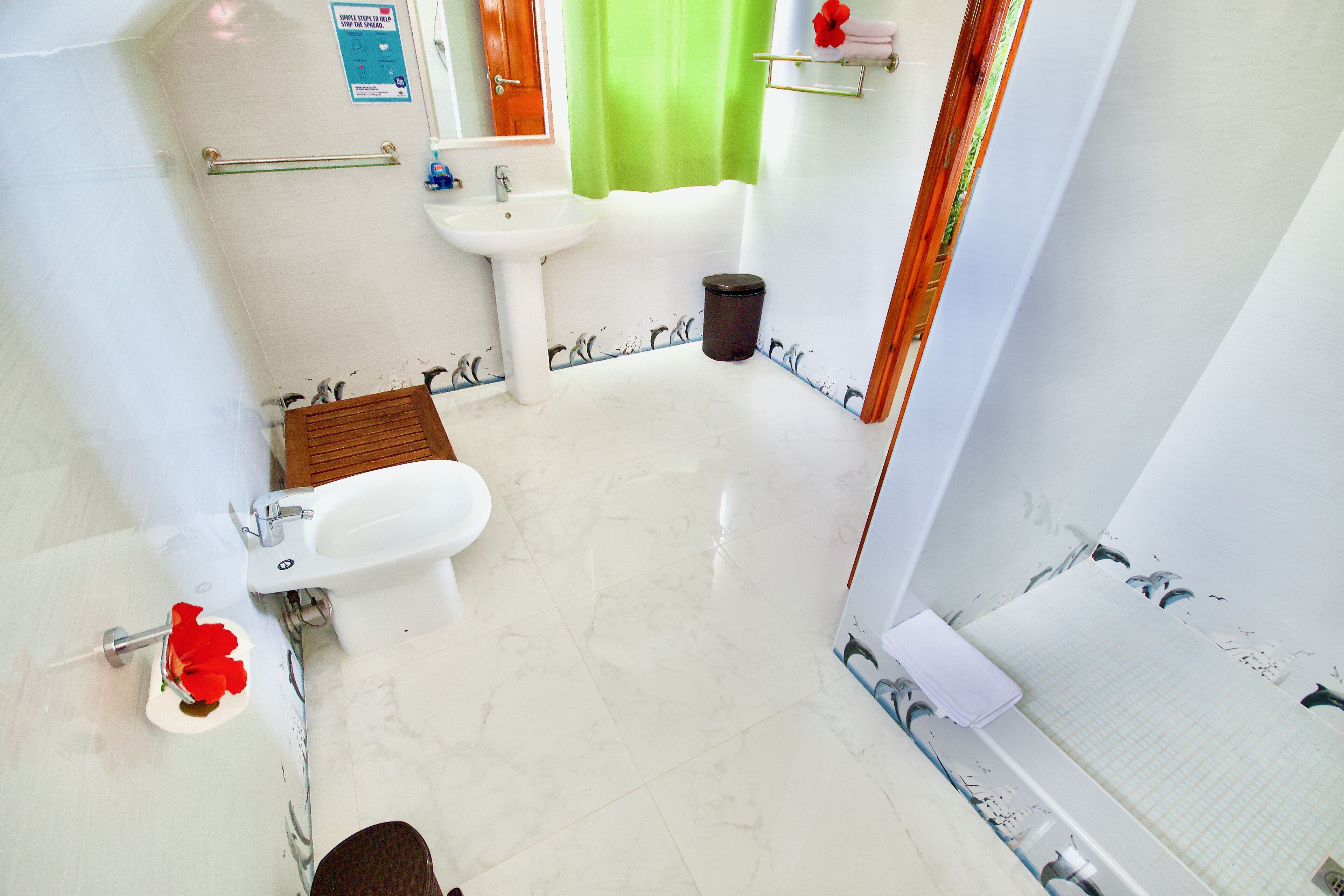 Uma casa de banho com sanita, lavatório e zona de duche.