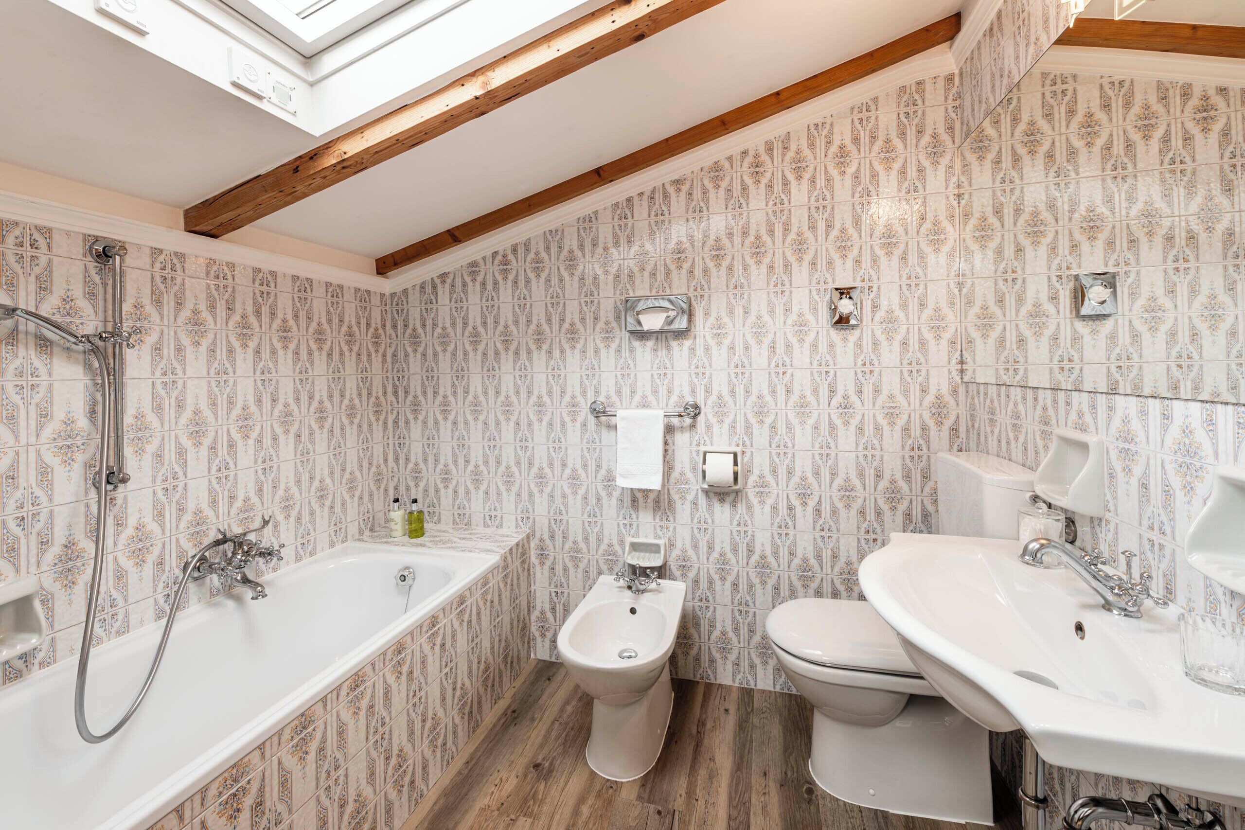 A bathroom with a freestanding bathtub, a bidet, a toilet, and a sink.
