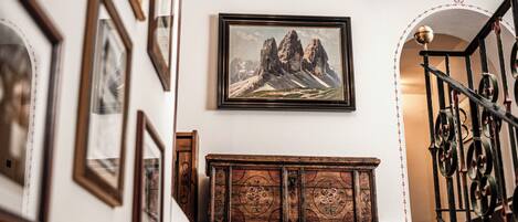 Una escalera con un banco de madera y cuadros en las paredes.