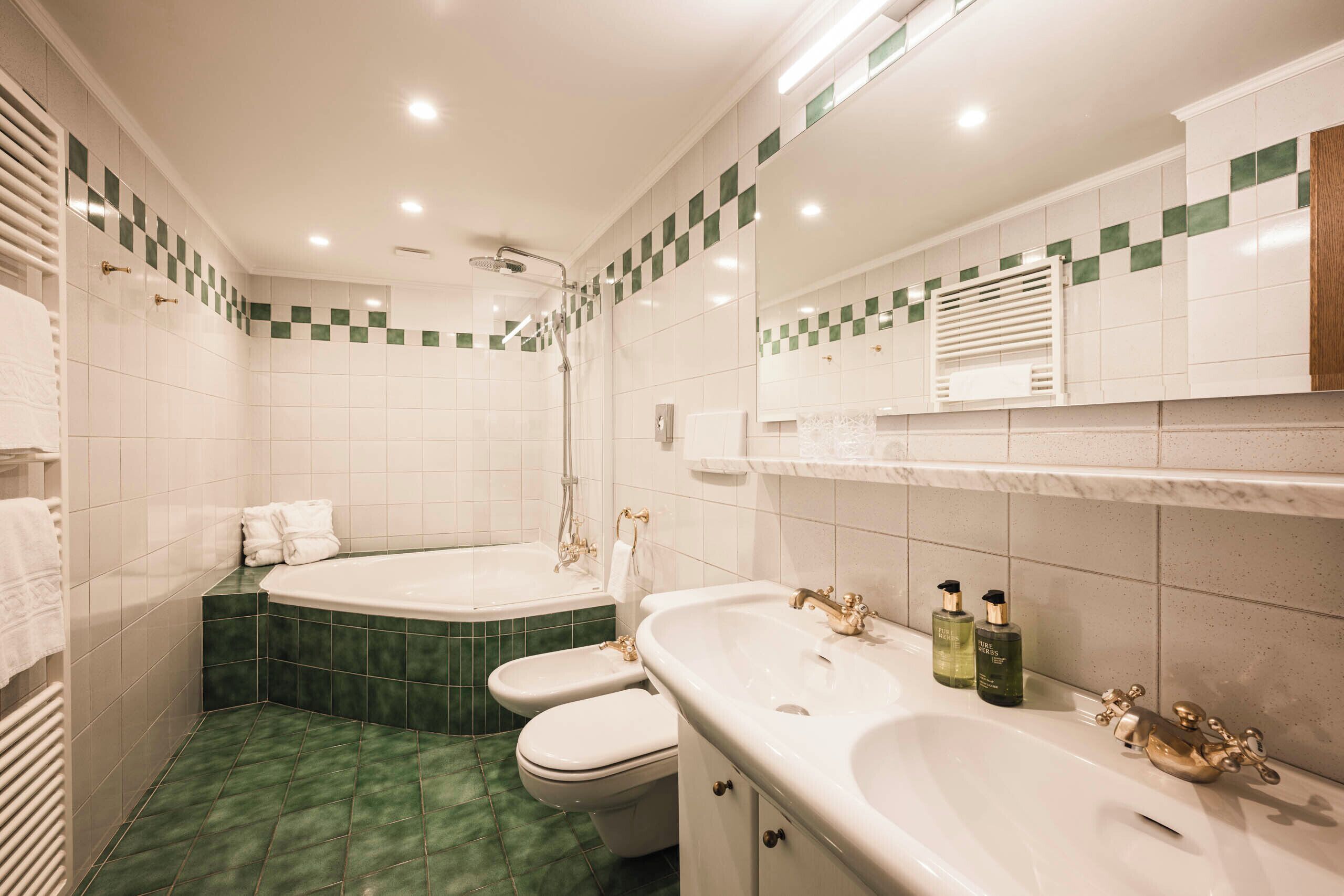Un baño con bañera, inodoro, lavabo y ducha.