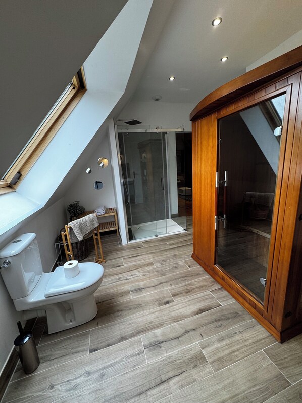 A modern bathroom with a skylight, a glass shower enclosure, and a wooden cabinet.