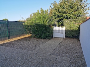Enter a serene oasis through the gated entrance, surrounded by lush greenery and a secure fence.
