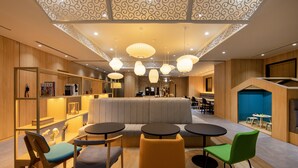 A modern interior with a central seating area, wooden paneling, and pendant lighting. - Karaksa Hotel Colors Tokyo Yaesu (Tokyo)