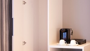 A compact hotel room with a wardrobe, a small refrigerator, and a microwave on a shelf. - Karaksa Hotel Colors Tokyo Yaesu (Tokyo)