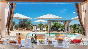A dining table set for two with a view of a pool and outdoor seating. - 3034 Villetta La Cornola by Barbarhouse (Taurisano)