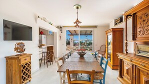 A spacious dining area with a long wooden table, multiple chairs, and a television mounted on the wall. - 3034 Villetta La Cornola by Barbarhouse (Taurisano)