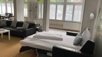 Ein modernes Zimmer mit einem Bett, einer Couch und einem Essbereich.