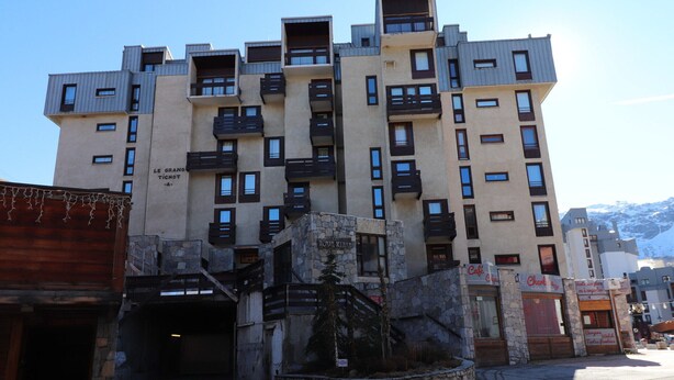 Un immeuble à plusieurs étages, doté de balcons et d’une façade en pierre.