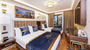 Habitación de hotel con dos camas, un cuadro grande, un escritorio con teléfono y vistas al exterior.