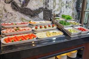 Buffet amb diverses opcions de menjar, incloent carn, formatge i verdures.