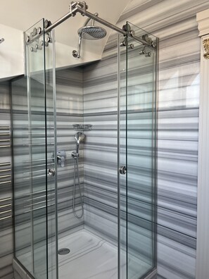 Habitación cuádruple Deluxe | Baño | Regadera, regadera tipo lluvia, amenidades de baño gratuitas