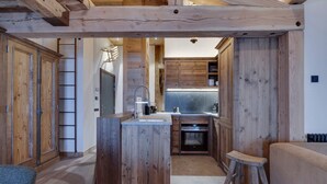 Une cuisine rustique avec des meubles en bois, un îlot central et un four encastré.