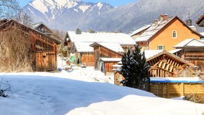 A snowy village with wooden houses and a mountain in the background. - Renovated apartment, 3 bedrooms, pets allowed, parking, close to Grand Massif (Morillon Village)