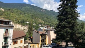 A hotel with a stone facade, a sign indicating it is a hotel, and a view of a mountainous landscape. - Renovated studio in the center for 2 people (Brides-les-Bains)