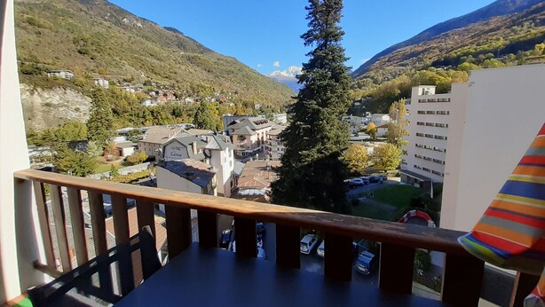 A balcony with a view of a town, a hotel, and mountains. - Renovated studio in the center for 2 people (Brides-les-Bains)