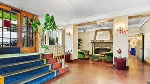 Eine Hotelhalle mit Treppe, Sitzgelegenheiten und einem Ausgangsschild.