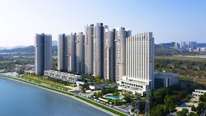 Un complesso residenziale di edifici a grattacielo con diverse torri, una piscina e vista sul lungomare.
