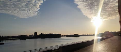 Une rivière avec un pont et, en arrière-plan, la silhouette d’une ville.