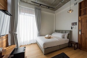 Un dormitorio moderno con cama, mesita de noche y un armario de madera.