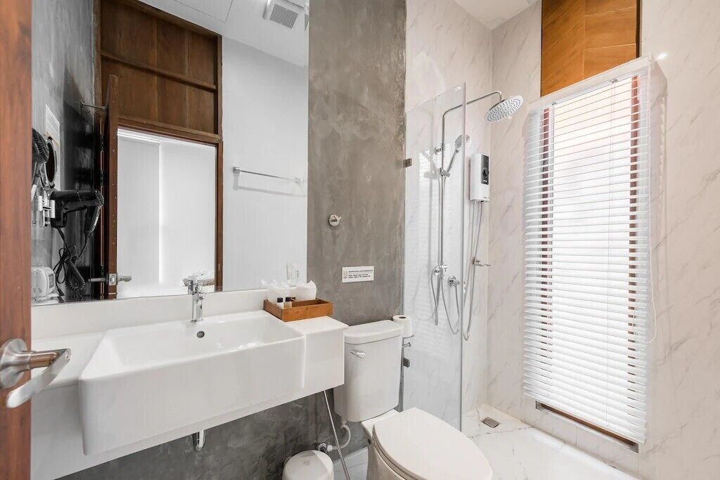 Un baño moderno con un lavamanos grande, inodoro y zona de ducha.