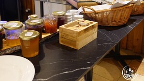 Una mesa de buffet con diversos alimentos y salsas.