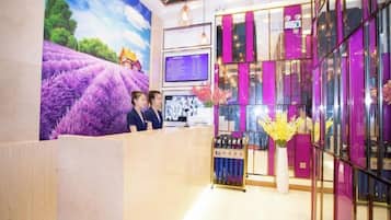 Un área de recepción con un gran mural floral, un mostrador de recepción y una exhibición de flores.