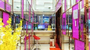 A modern hotel lobby with a central staircase, glass partitions, and a purple color scheme. - Liman Hotel (Guangzhou)