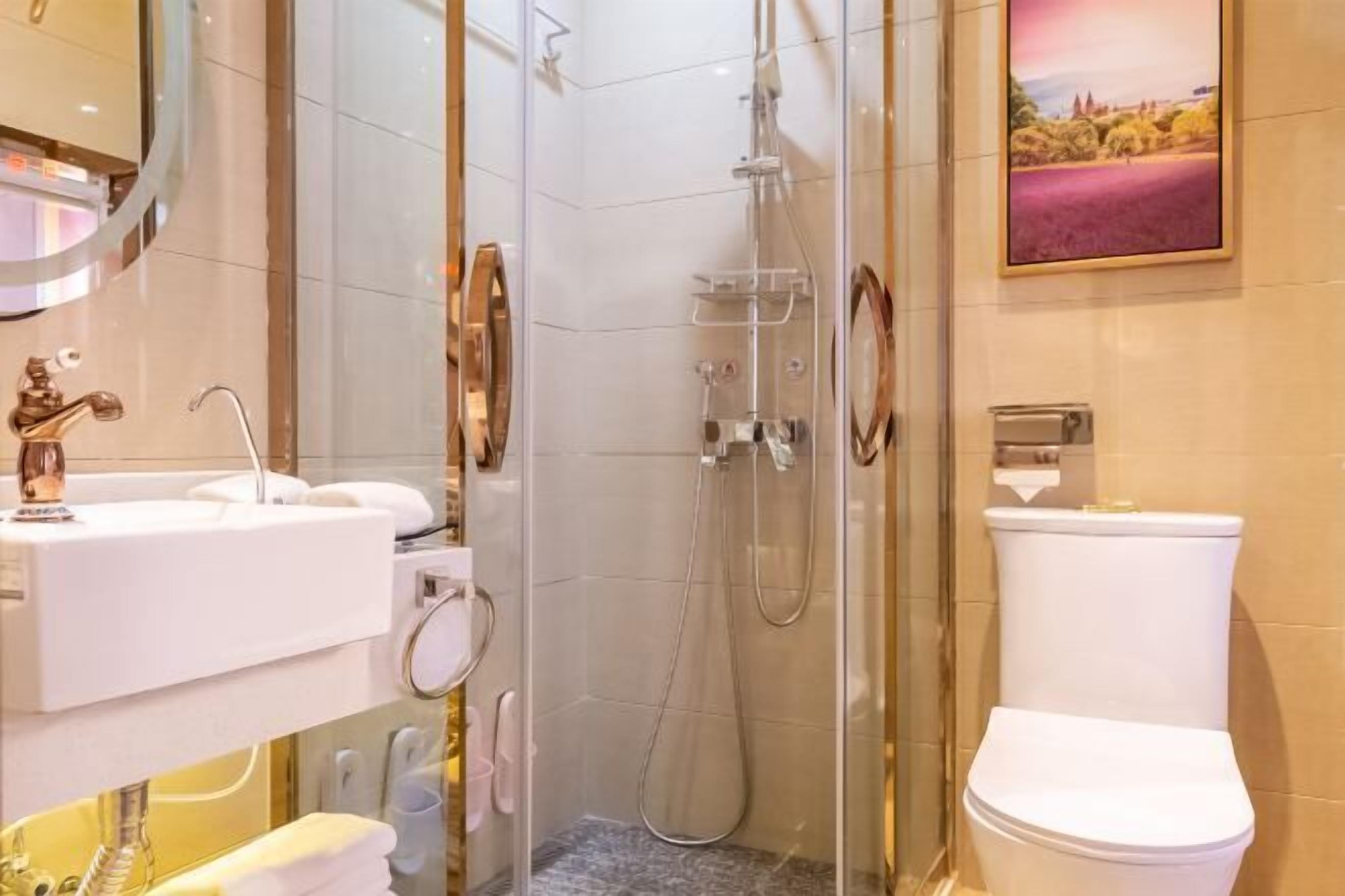 Um banheiro moderno com chuveiro em vidro, pia branca e vaso sanitário.