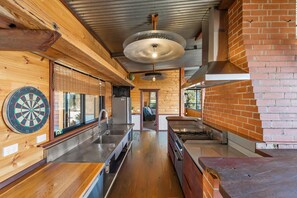 A kitchen with a dartboard, a sink, and a stove. - Big Hill Rustic Retreat (Big Hill)