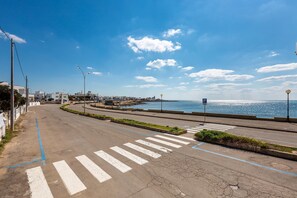 A coastal road with a pedestrian crossing, a parking area, and a view of the sea. - 2756 Villa Verdemare - Appartamento B by Barbarhouse (Ugento)