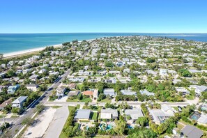 A coastal residential area with houses, a beach, and a clear blue sky. - H2O Bungalow by Beach Boutique Rentals (Anna Maria)