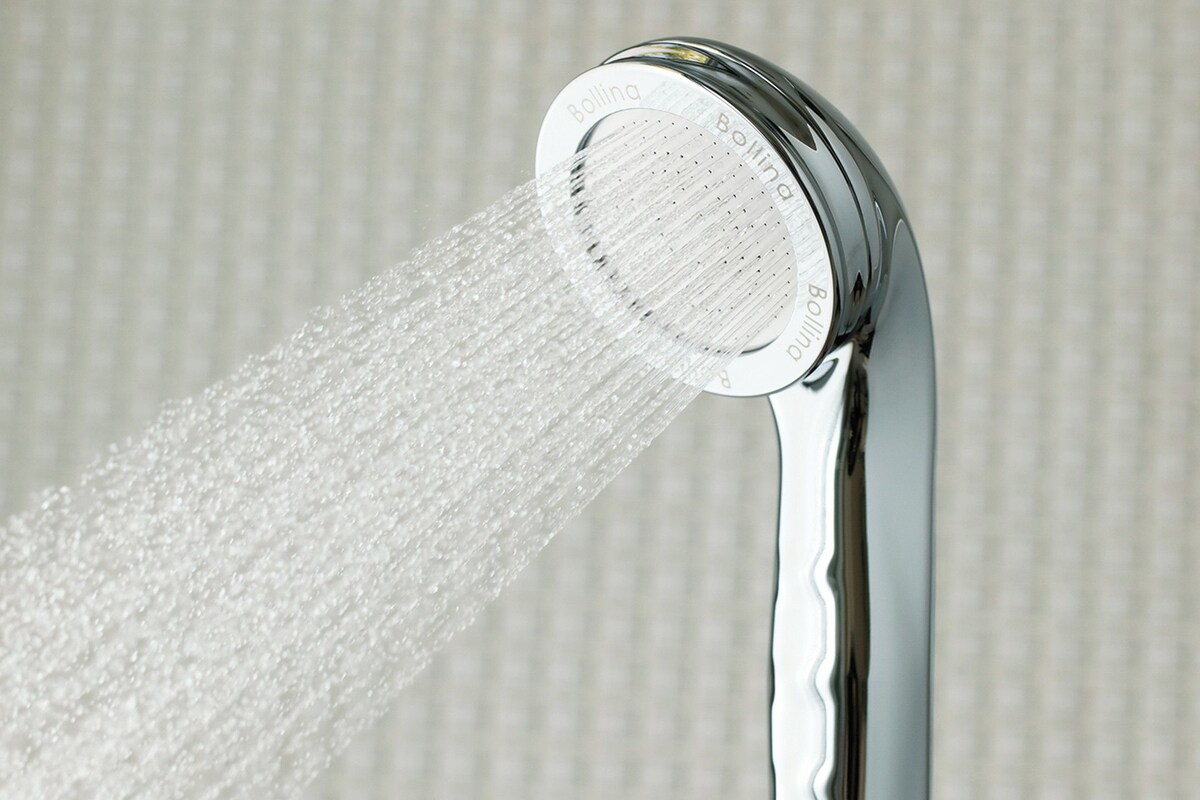 A showerhead with water flowing from it.
