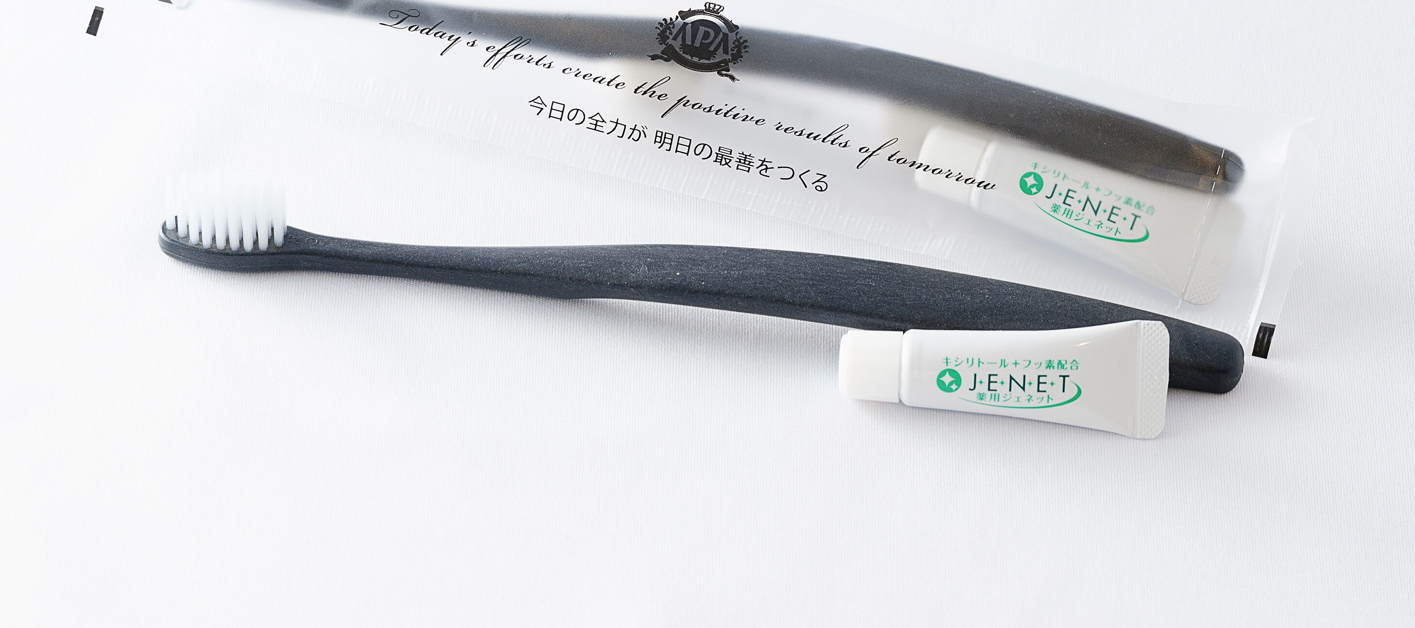 A toothbrush and a toothbrush holder with Japanese text.