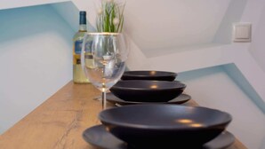 A dining table with plates and a wine glass, a bottle, and a pendant light. - Comfortable Studio in Cracow | Place to Work | Close to Market Square (Kraków)