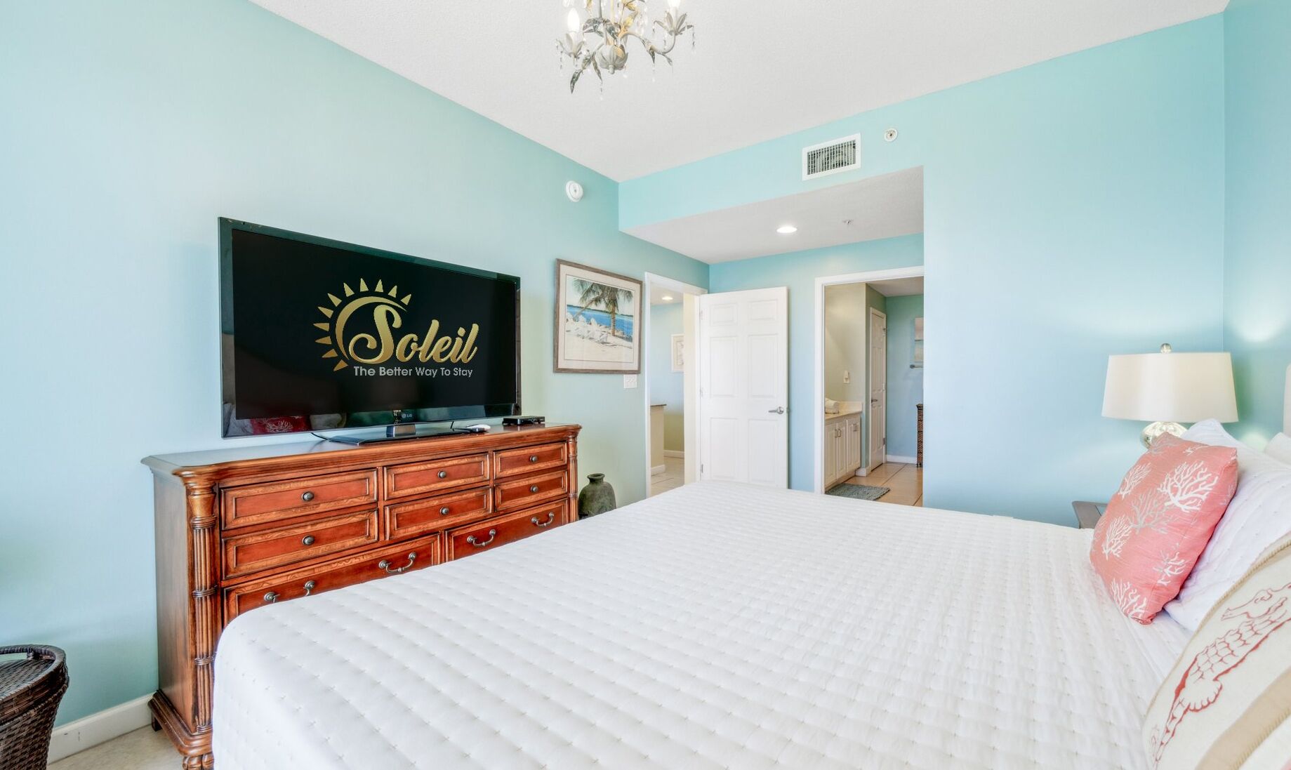 Ein Schlafzimmer mit Bett, Kommode, Fernseher und einem Bild an der Wand.