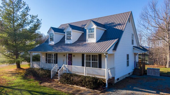 A two-story white house with a dark roof, a front porch, and a small attached garage. - Petes Alpine Retreat - pet friendly Seven Devils home close to ziplining, snow tubing (Seven Devils)