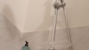 Ducha con cabezal de ducha de mano y grifo empotrado.