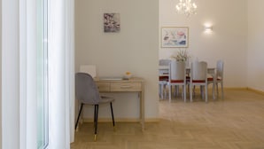 A dining area with a wooden table, chairs, and a chandelier. - The Bright Suite (Corfu)