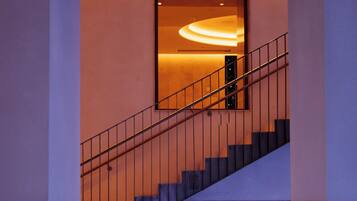 A modern staircase with a glass railing leading to a lower level.