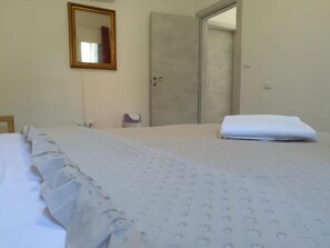 A hotel room with a bed, a door, and a mirror on the wall. - Venice Cityview Guesthouse (Mestre)