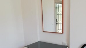 A room with a white dresser, a mirror with a wooden frame, and a black metal railing. - Venice Cityview Guesthouse (Mestre)
