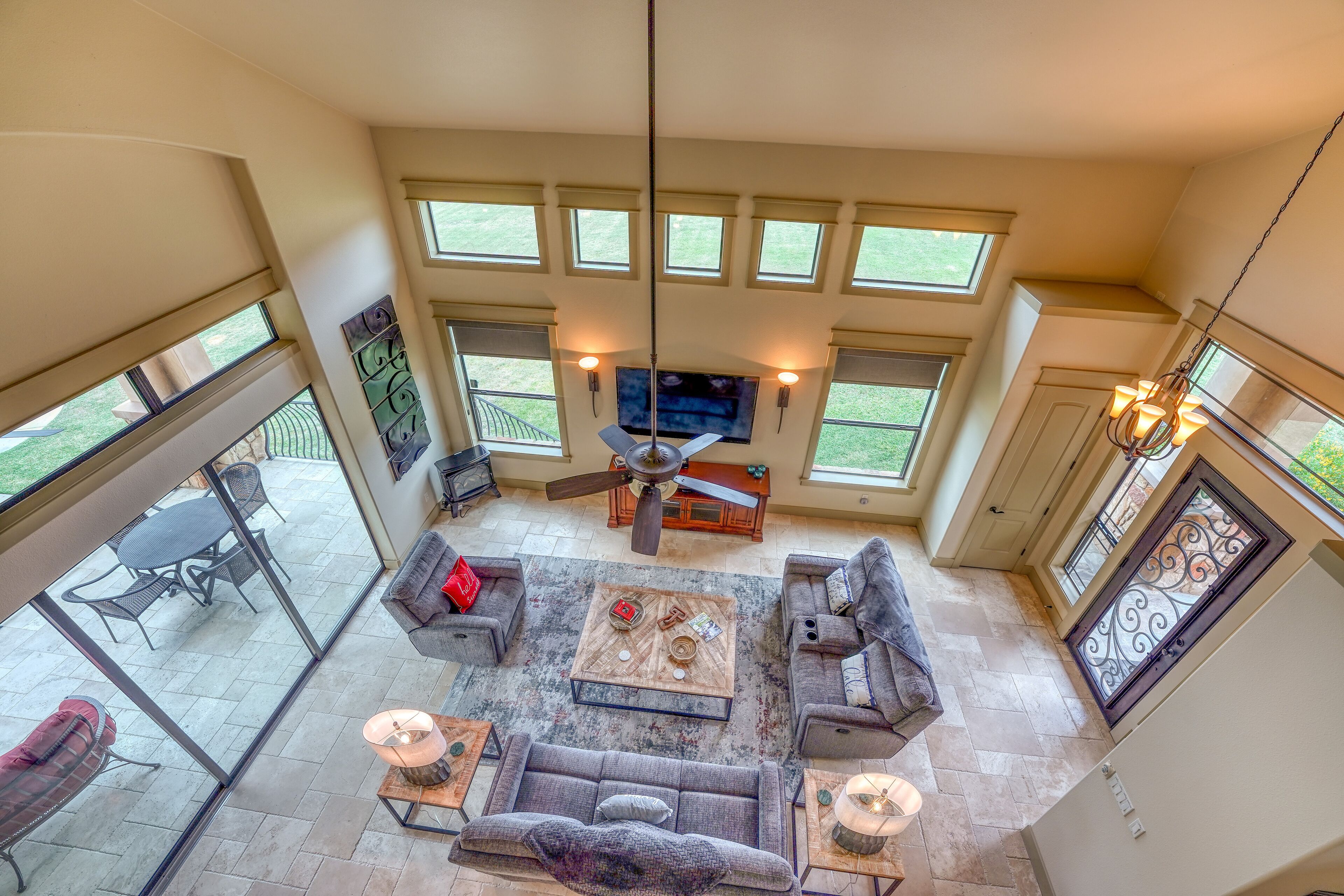 A spacious living area with a ceiling fan, a flat-screen TV, and a dining table with chairs.
