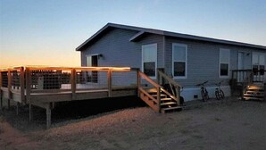 A single-story building with a covered deck and a staircase leading to a second level.