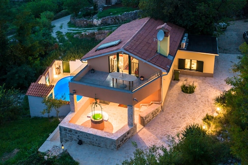 A rustic stone house with pool and sea views.