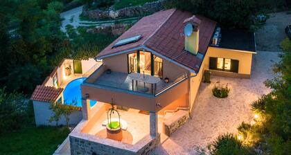 A rustic stone house with pool and sea views.