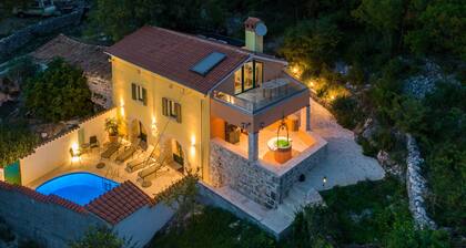 A rustic stone house with pool and sea views.