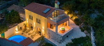 A rustic stone house with pool and sea views.