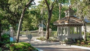 Ein Pavillon mit Ziegeldach, umgeben von Bäumen und einem verschlossenen Eingang.